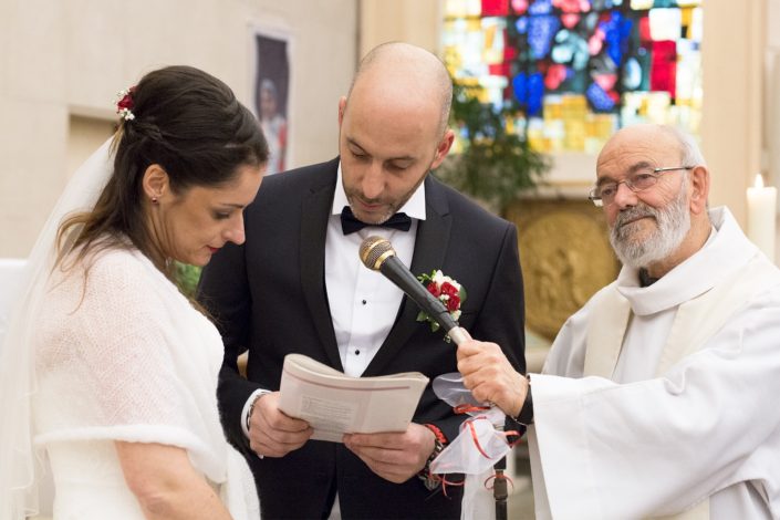 le marié lit les textes sacrés devant le prêtre