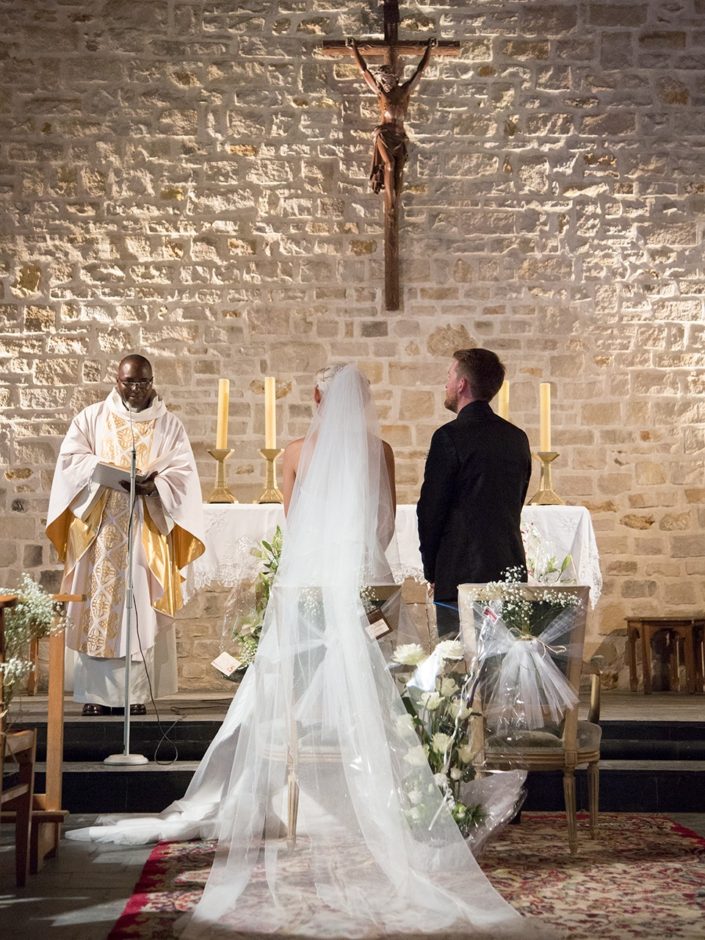 traine robe de mariée et marié devant le prêtre