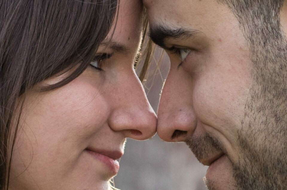 Plan serré, du front au menton sur un tête à tête d'un jeune couple bruns. On les voient de profil, se regardant dans les yeux, le nez se touchant